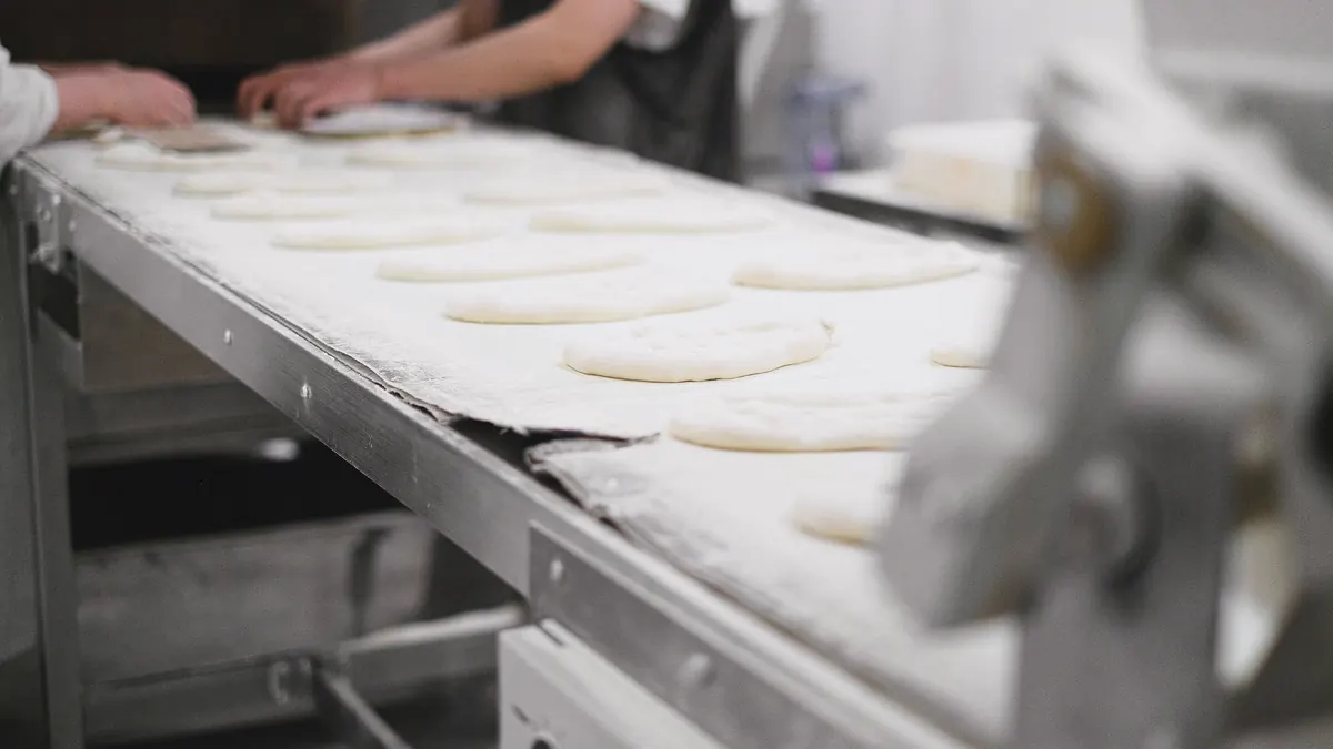 Deegstukken op een productieband in een industriële bakkerij