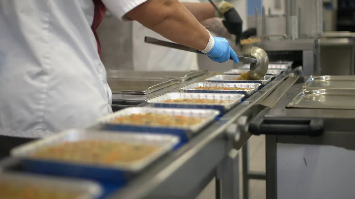 Maaltijdbakjes worden op een lopende band gevuld