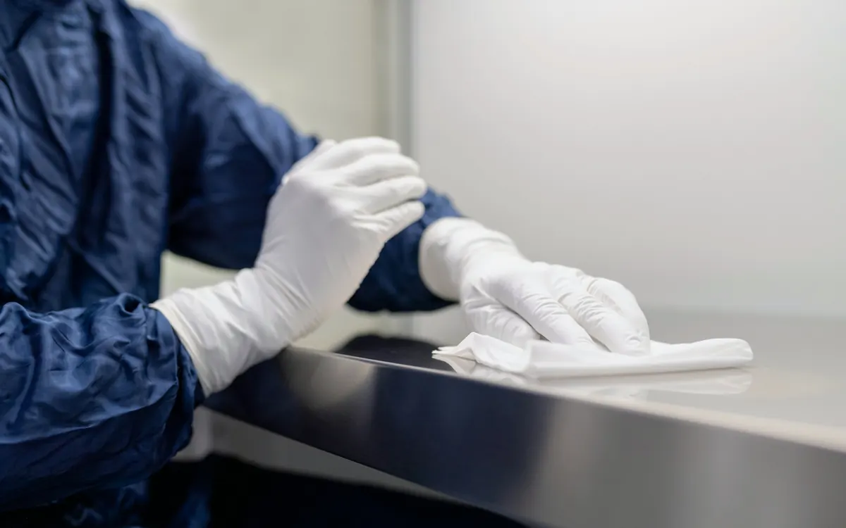 Handen in handschoenen reinigen een RVS-werkblad