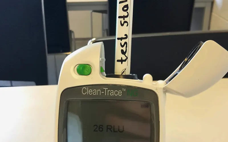 ATP-meter met swab en een meetuitslag in RLU op het display